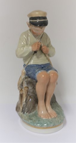 Royal Copenhagen. Porcelænsfigur. Siddende dreng i farver. Model 905. Højde 19 
cm. (1 sortering)