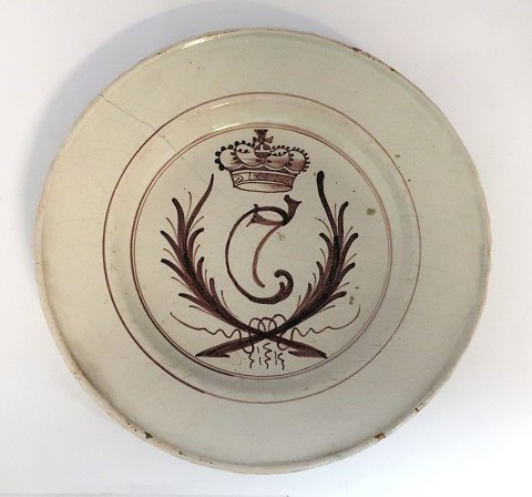 Fayence aus der Store Kongensgade. Teller in Braun mit dem gekrönten Monogramm 
von Christian VIII. verziert. Durchmesser 24 cm.